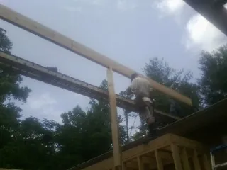 Carpenter setting a ridge beam over a new addition frame — Ice Dam Removal by Roofing Brothers in Irvona