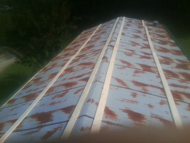 Rusted metal roof panels with new wood purlins before replacement — Storm Damage Roof Repair in Irvona by Roofing Brothers