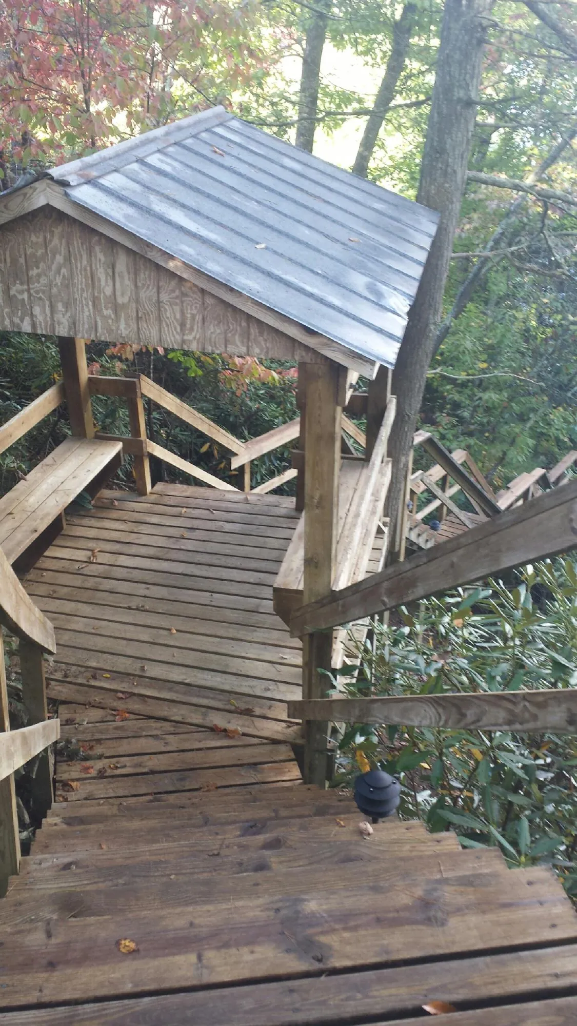 Metal roofed shelter over wooden steps on a wooded walkway — Skylight Repair & Installation work by our crew in Irvona