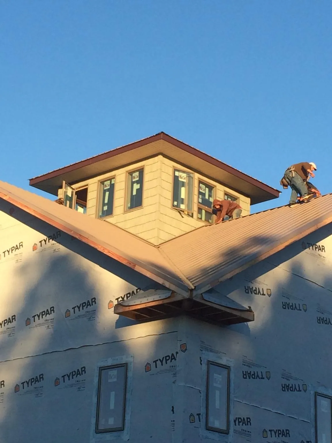 Roofers working around a rooftop cupola on a new metal roof at sunset — Roof Waterproofing in Irvona by Roofing Brothers